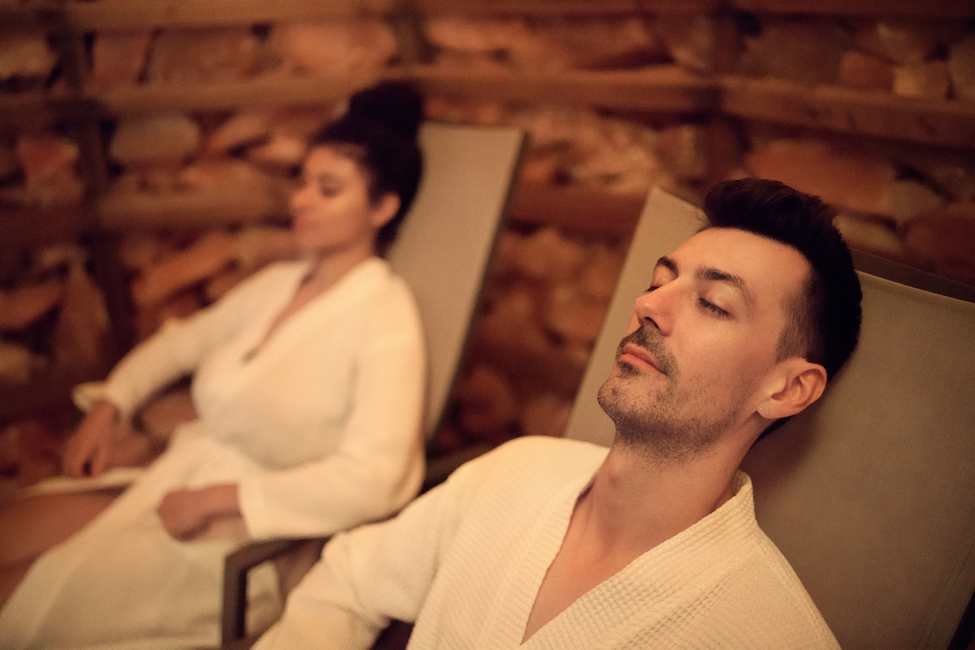 Portrait of young couple in salt inhalation steam room, relaxing